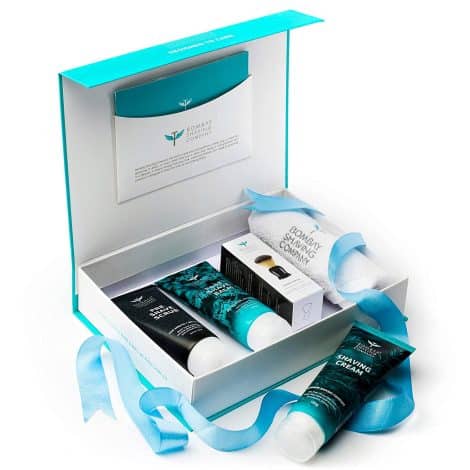 Complete men’s grooming kit including exfoliating scrub, shaving cream, post-shave balm, shaving brush, and towel.